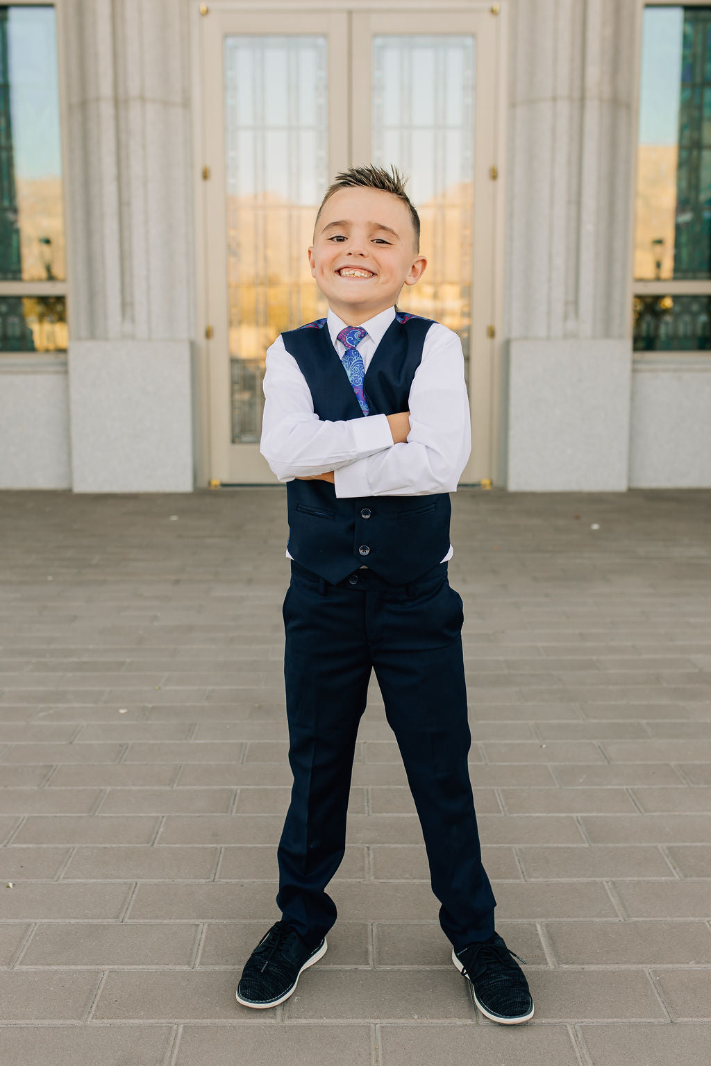 boy in navy dress pants and vest