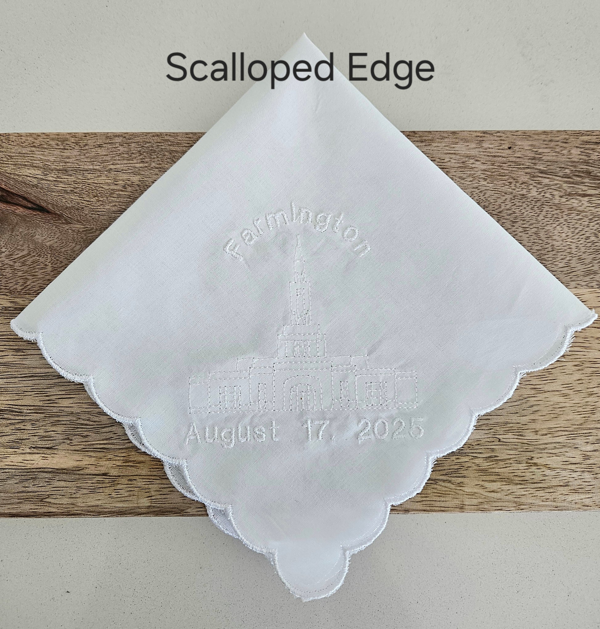 White hankie with embroidered temple and date.