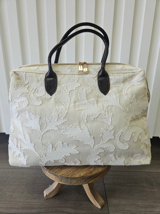 Beige zipper top purse with light beige appliques.