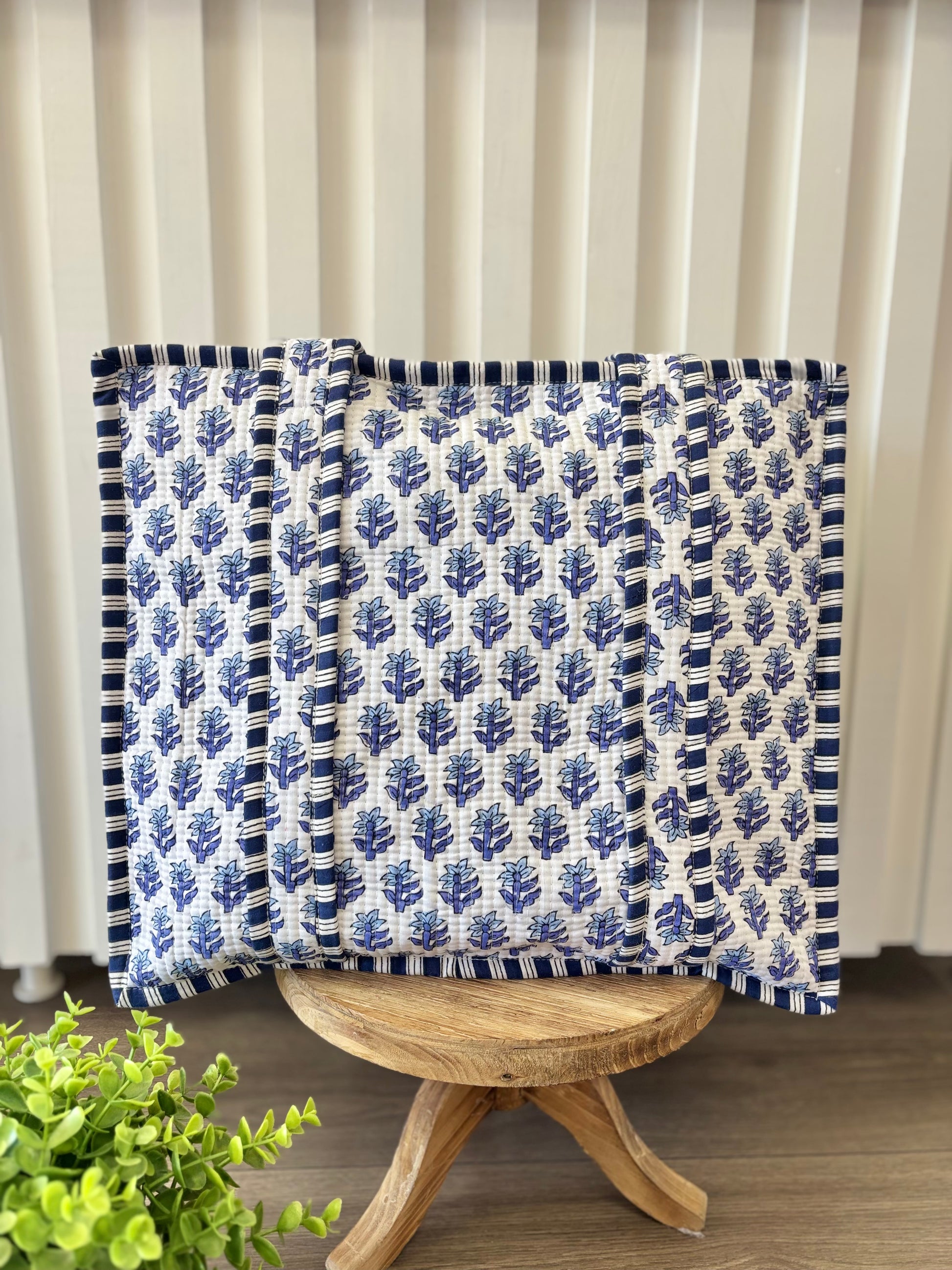 blue floral quilted bag on wood stool
