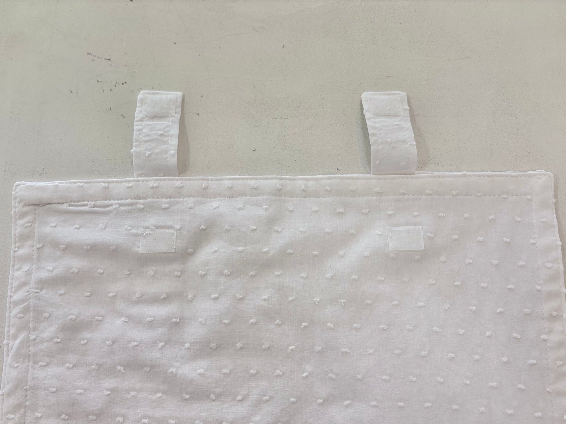 White cotton envelope with Velcro strap closure.
