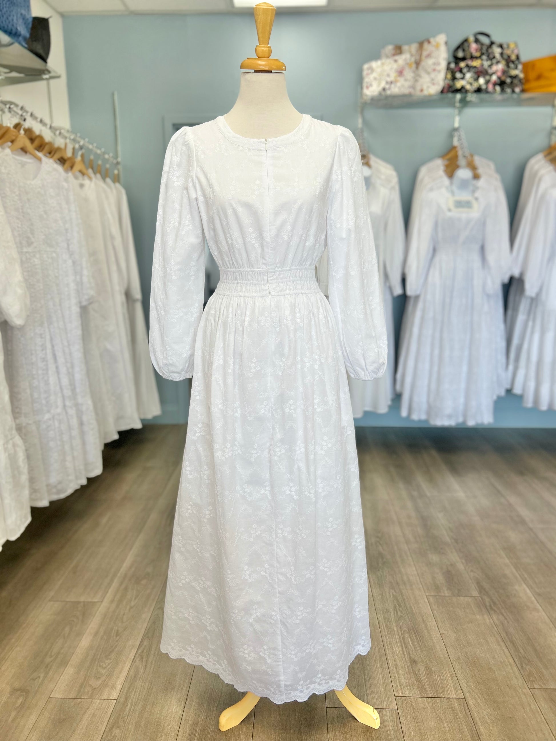 White cotton zip front dress with scalloped hem.