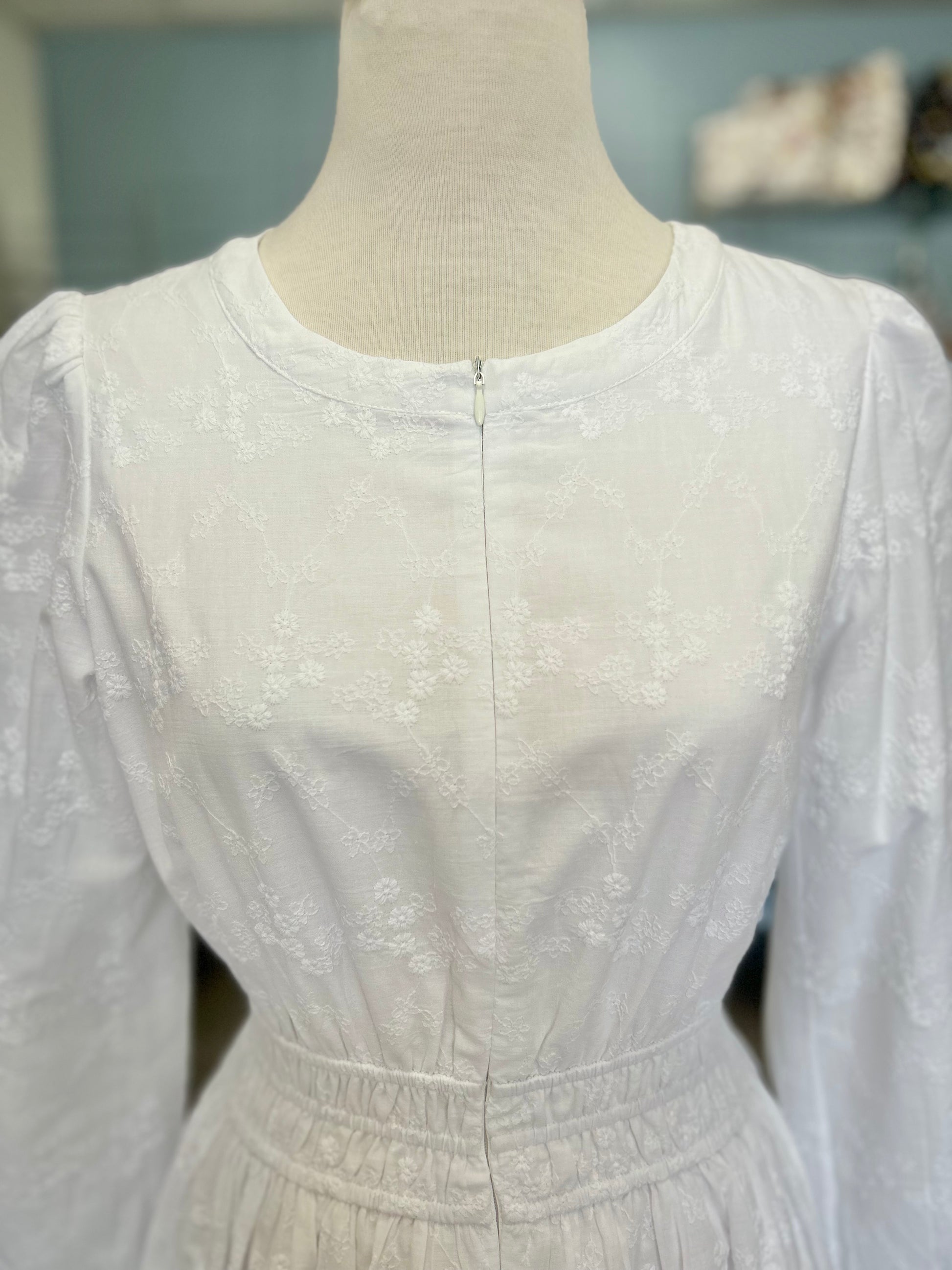 White zip front dress with embroidered design.