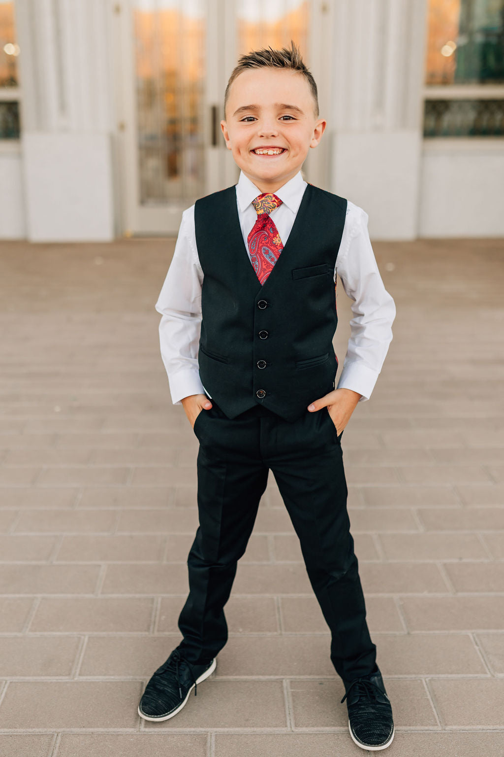 boy in black dress pants and matching vest
