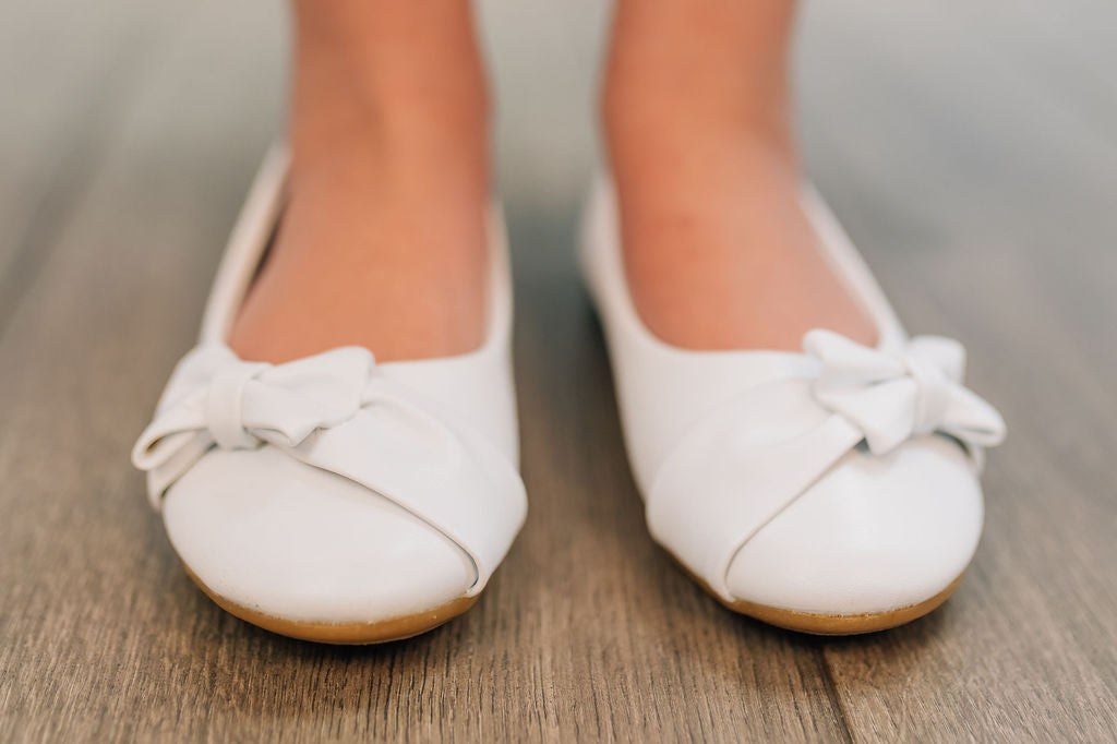 white flat shoe for girls with bow on the toe
